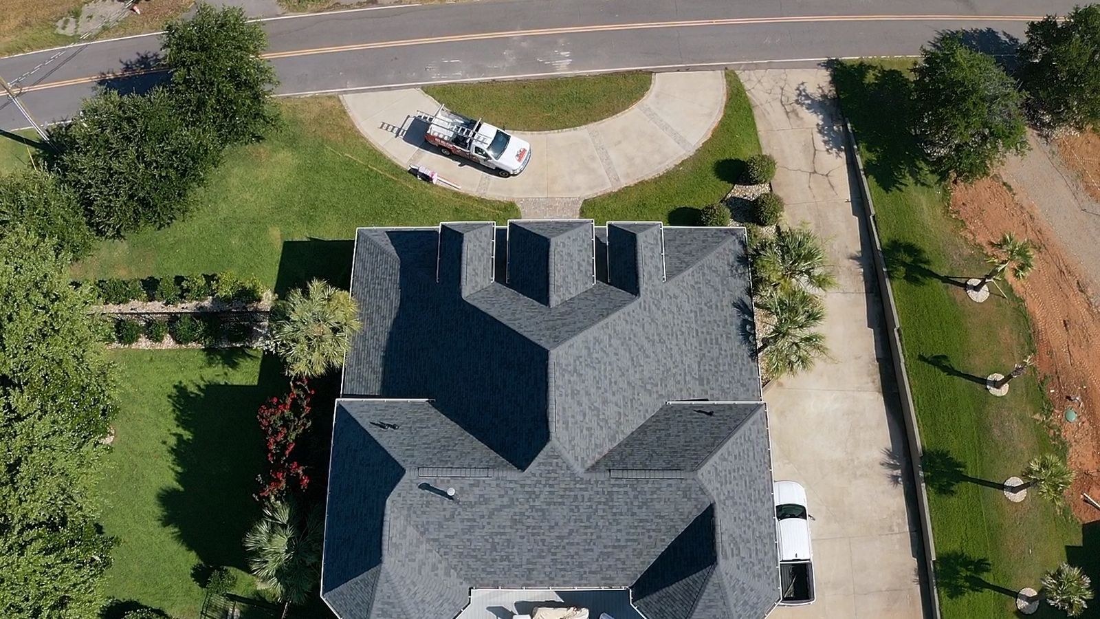Aerial view of a completed charcoal architectural shingle roof with multiple hips and gables in the South Carolina Midlands
