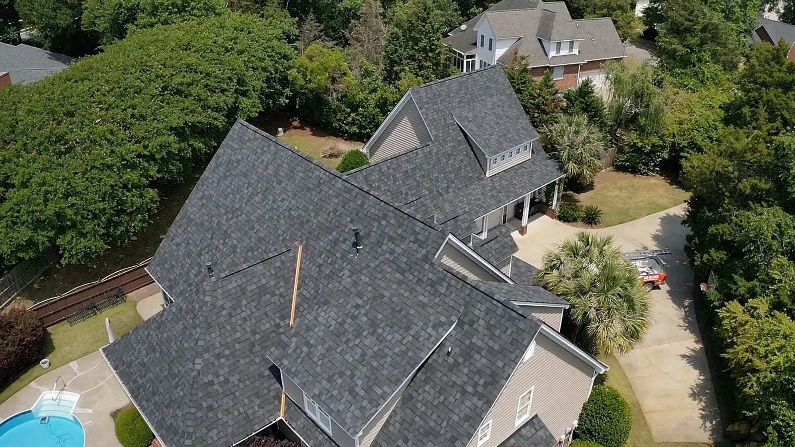 Aerial view of a completed architectural shingle roof on a large home with a pool in the South Carolina Midlands