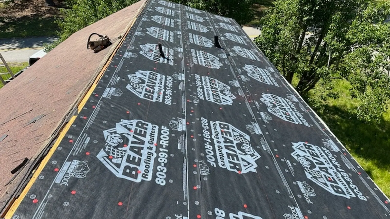 Beaver Roofing branded synthetic underlayment installed across a roof deck before shingles go on