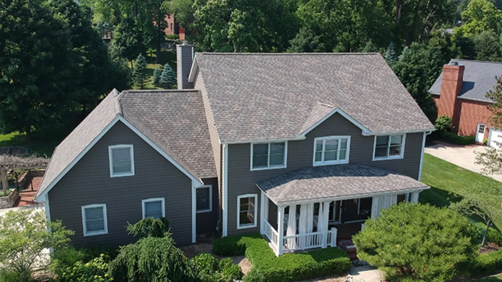 Aerial view of a completed architectural shingle roof on a two-story home with dark blue siding in the South Carolina Midlands
