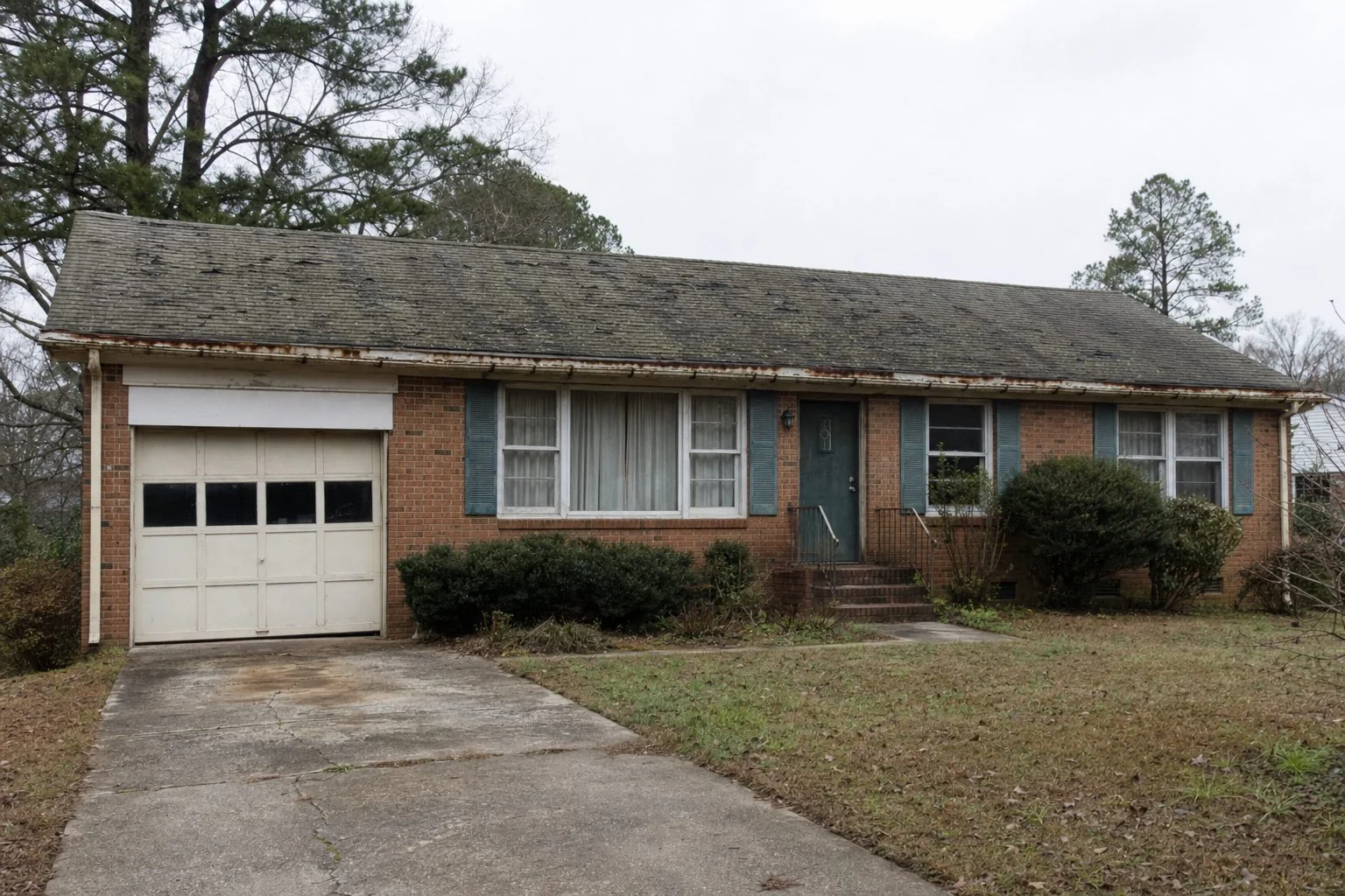 Aging algae-streaked asphalt shingle roof on a South Carolina home showing granule loss before replacement
